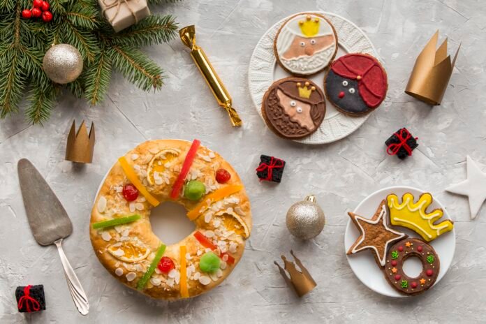 Sobremesas de Natal decorativas em uma mesa festiva com biscoitos decorados e bolo natalino.