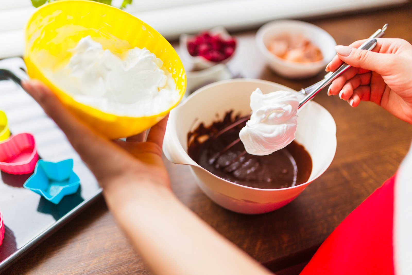 Preparação de sobremesa com três ingredientes, incluindo creme e chocolate, em tigelas coloridas, ideal para receitas rápidas e práticas.