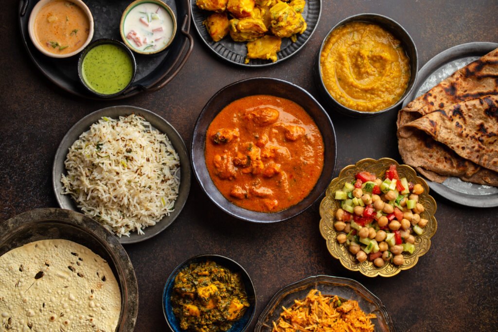 Pratos típicos da culinária indiana com curry, arroz, dhal, salada e chapati.