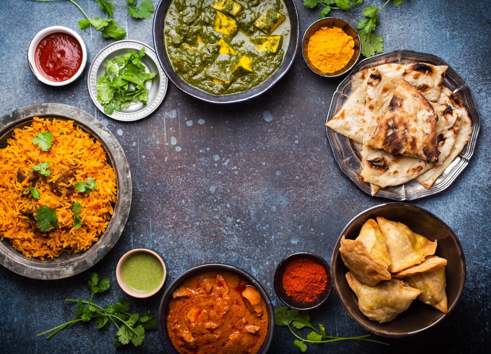 Pratos tradicionais da culinária indiana com arroz, pão naan, samosas e curry.