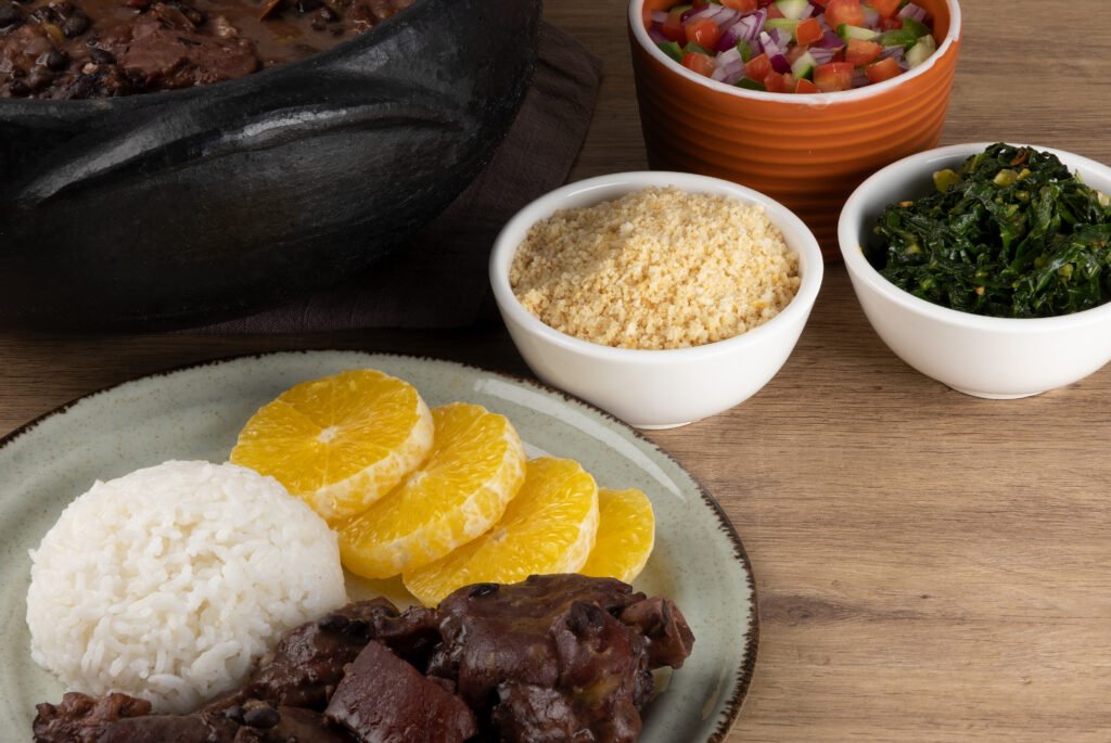 Feijoada brasileira com acompanhamentos de arroz, laranja, farofa e couve