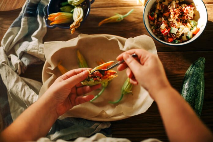 Preparação de prato criativo com sobras de alimentos em uma cozinha aconchegante.