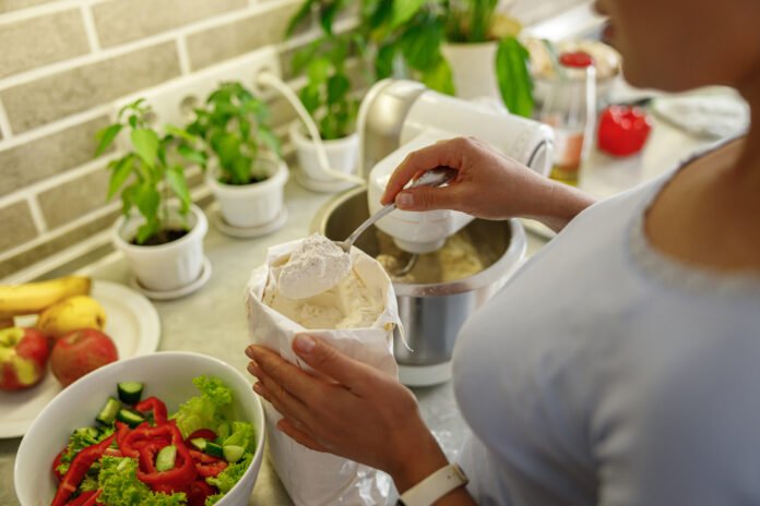 Pessoa preparando uma receita funcional com ingredientes frescos em uma cozinha organizada.