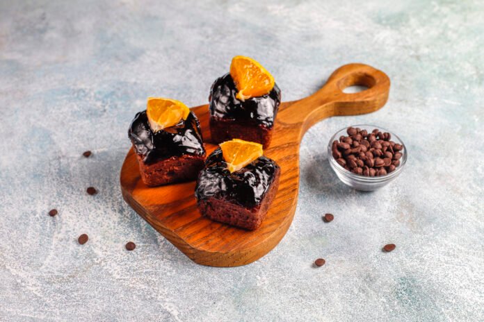 Brownie de café com toque de laranja servido em uma tábua de madeira.