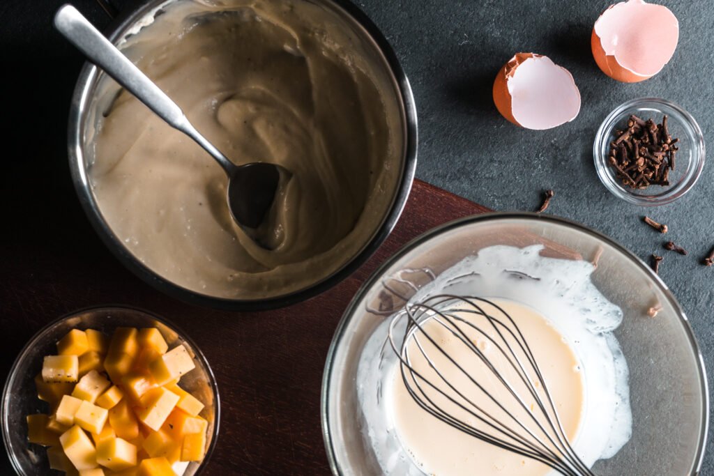 Ingredientes e preparações para sobremesas com camadas de texturas diferentes, incluindo creme e queijo.