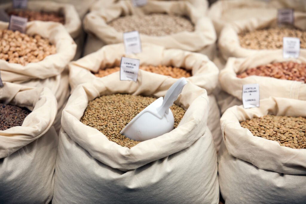 Sacos de alimentos a granel com lentilhas, feijões e grãos em um mercado sustentável.