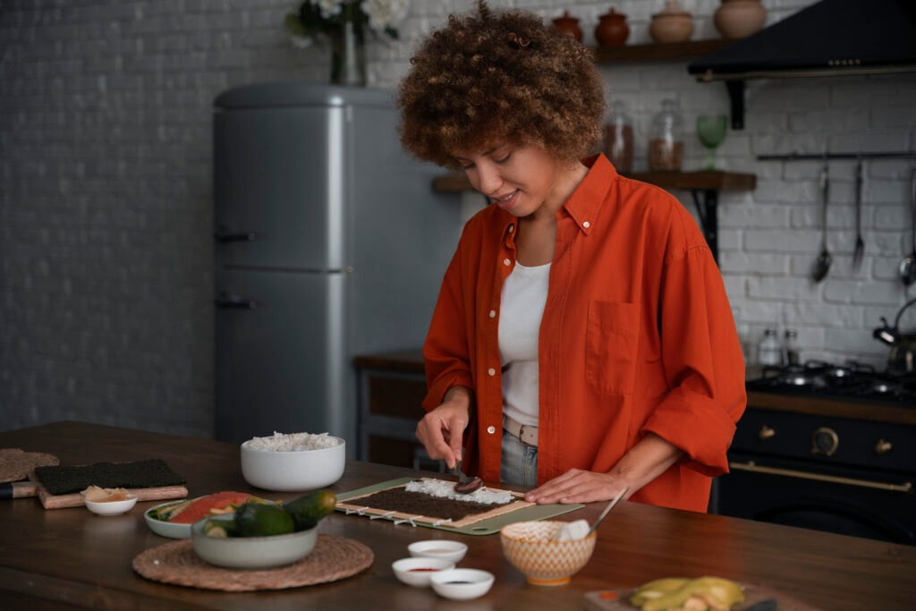 Mulher preparando sushi com ingredientes frescos como alternativa saudável na cozinha.